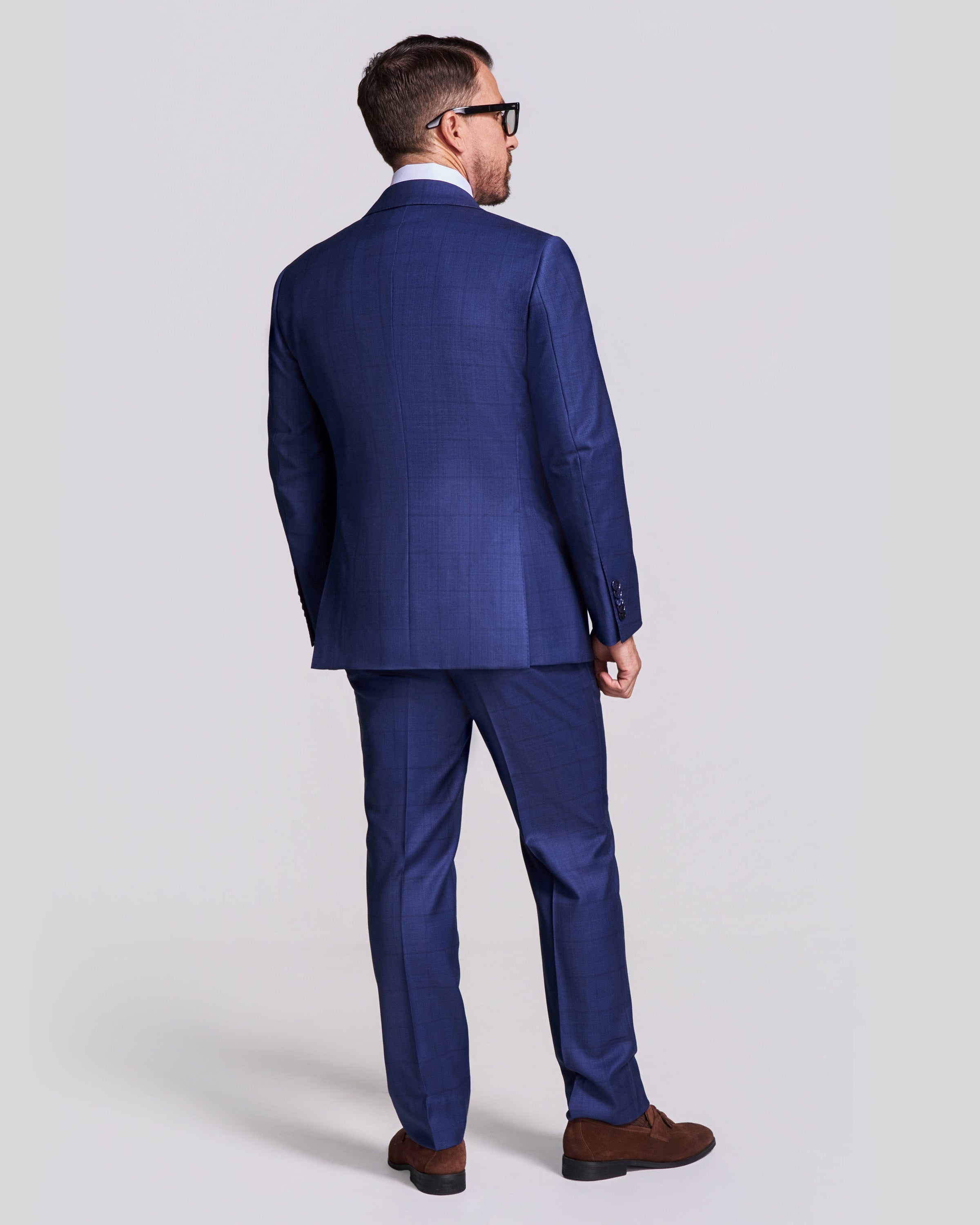 Man wearing a blue suit on a light gray background