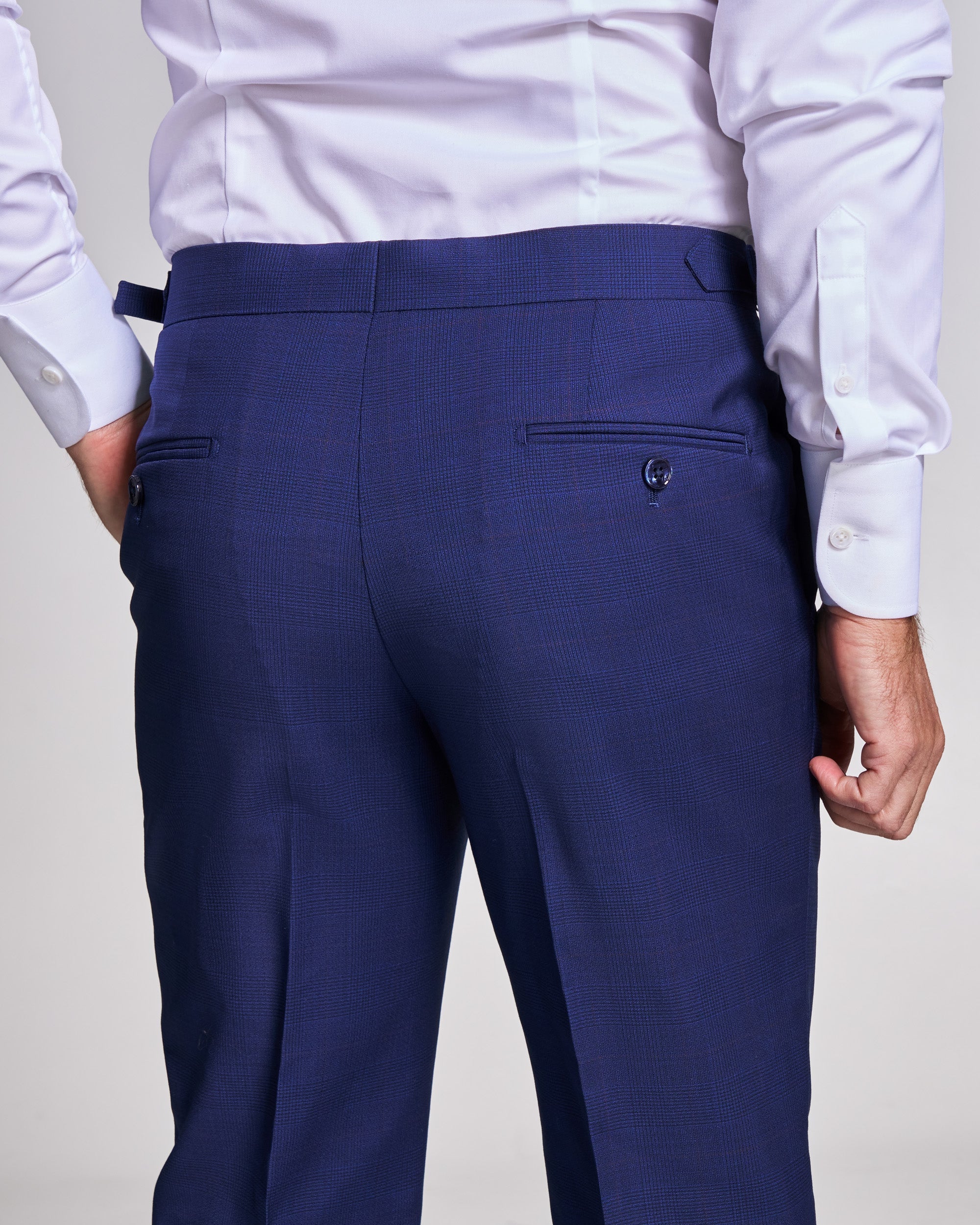 Navy blue dress pants worn with a white shirt on a plain background