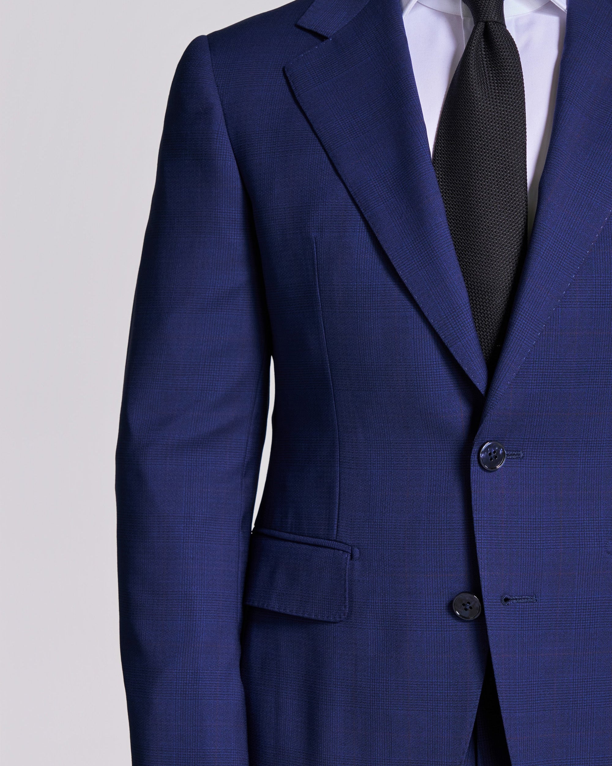 Blue suit jacket with a black tie on a light gray background