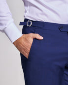 Navy blue suit pants with a white shirt on a light gray background